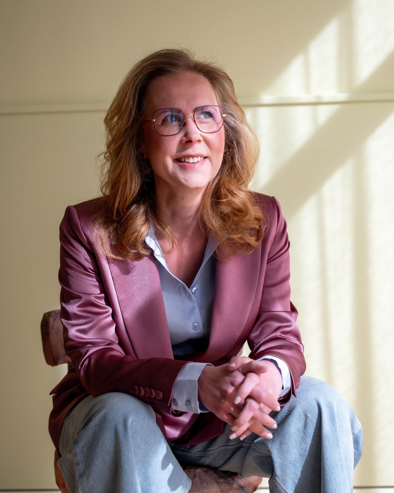 Marcelle van Brummelen, holistische therapeut bij Journey Balance Barneveld, zittend met gevouwen handen en blik omhoog